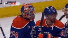 a hockey player with the number 74 on his jersey stands on the ice