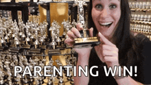a woman holding a trophy with the words parenting win written on the bottom