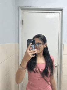 a girl taking a picture of herself in the mirror