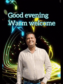 a man in a white shirt is smiling in front of a sign that says good evening warm welcome