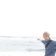 a person is standing on a beach with their arms outstretched .