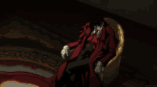 a man in a red coat and tie sits in a chair