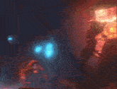 a blurred image of a person in a dark room with a glowing object in the background