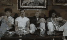 a group of people are sitting at a table with glasses of wine .