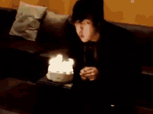 a person is blowing out candles on a birthday cake