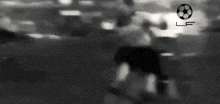 a black and white photo of a soccer player kicking a ball on a field .