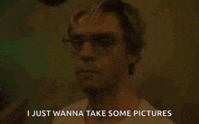 a man wearing glasses and a white shirt is talking about taking some pictures .