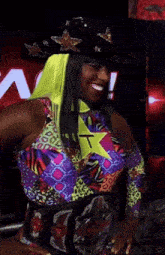 a woman in a colorful outfit with a yellow star on her chest stands in front of a sign that says rinshow