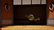 a toy frog is standing in the doorway of a wooden building