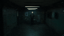 a man singing into a microphone in a dark room with a sign on the wall that says ' a '