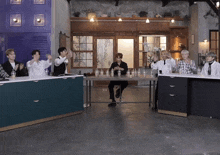 a group of young men are sitting around a table with bottles of liquid on it