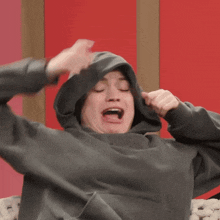a person wearing a grey hoodie with the letter n behind them