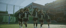 a group of girls in school uniforms are running in a field