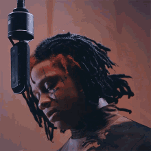 a woman with dreadlocks smoking a cigarette in front of a microphone that says jbl on it