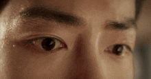 a close up of a man 's eye with sweat coming out of it .