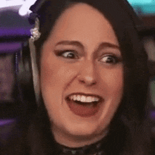 a close up of a woman wearing headphones and smiling .