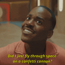 a man in a pink shirt is smiling and says did i just fly through space on a confetti cannon
