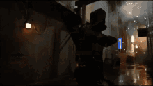 a man in a gas mask is standing in a dark alleyway with a blue sign that says ' a ' on it