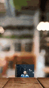 a picture of a boy in a graduation cap and gown on a wooden table