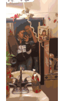 two people taking a selfie in front of a mirror with a picture of a girl on the wall above them