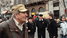 a man wearing a hat stands in front of a sign that says ' allianz '