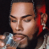 a man with a beard is drinking from a clear glass