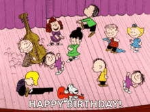 a group of peanuts characters are dancing on a stage with the words happy birthday