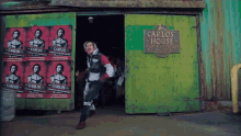 a man is running in front of a carlos house sign