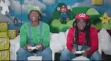 two men dressed as mario and luigi are playing a video game on a couch .