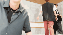 a man in a black shirt is standing in a room with other people