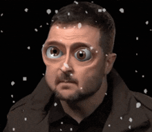 a man with a beard is wearing a mask that looks like alien eyes