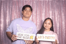 a man and a woman holding signs that say here for the beer