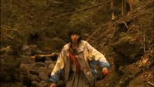 a person laying on a rocky path with a tv channel visible