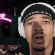 a close up of a man wearing headphones and a bandana .
