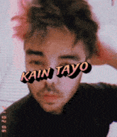 a close up of a man 's face with kain tayo written on his forehead