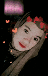 a woman wearing a hijab with red hearts around her head