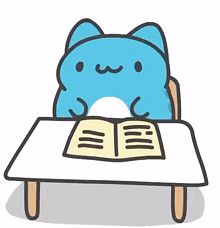 a blue cat is sitting at a table with a book .