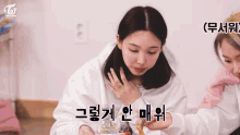 a woman with a ring on her finger is sitting next to another woman eating food .