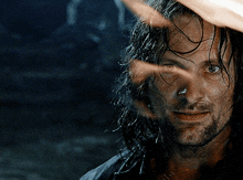 a close up of a man 's face with wet hair and a beard