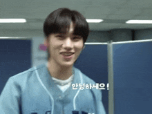 a young man wearing a blue baseball uniform is smiling and talking in korean