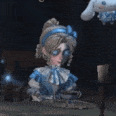 a girl in a blue dress is sitting at a table with a tray and a stuffed animal in the background .