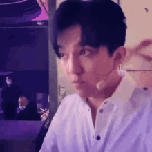a man wearing a white shirt and a microphone on his ear .