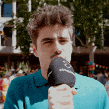 a man wearing a blue shirt is holding a microphone that says atresplay