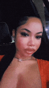 a woman wearing a red top and a necklace with the letters cc on it