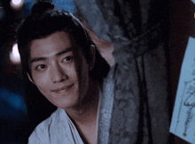 a close up of a young man peeking out from behind a wall .