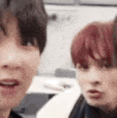 two young men with red hair are sitting next to each other .