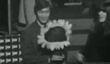 a black and white photo of a man and woman standing next to each other in a dark room .