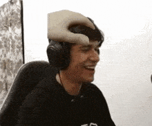 a man wearing headphones is being patted on the forehead by someone 's hand .