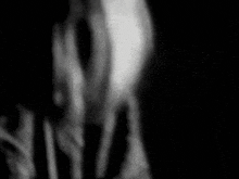 a black and white photo of a person 's face in the dark