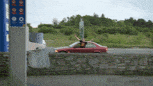 a man sitting in a car with his arms outstretched in front of a sign that says 00